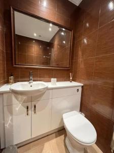 a bathroom with a toilet and a sink and a mirror at Spacious 2Bed/2Bath Flat next to London Eye in London