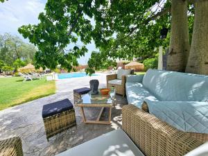 a patio with a couch and chairs and a table at CHALET ALICANTE Sol y Luz in San Vicente del Raspeig