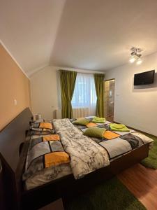 a bedroom with two beds and a flat screen tv at CASA IKA&MATEI in Borşa