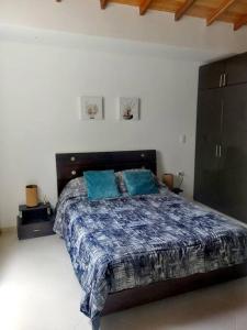 1 dormitorio con 1 cama con edredón azul en Cómodo Apto. Excelente Ubicación, en San Gil