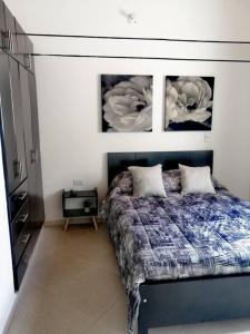 1 dormitorio con 1 cama con 3 cuadros en la pared en Cómodo Apto. Excelente Ubicación en San Gil