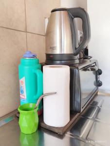 a coffee pot and a roll of paper towels and a green cup at Departamento monoambiente hasta 4 personas- Maragus2 in Posadas