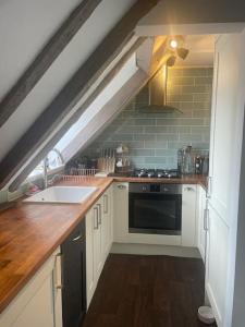 a kitchen with a sink and a stove at Beautiful 1600’s loft apartment. in Ware