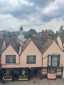 a large white building with windows in a town at Beautiful 1600’s loft apartment. in Ware