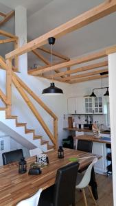 a kitchen with a wooden table with chairs and a staircase at Vila Sava in Sopot