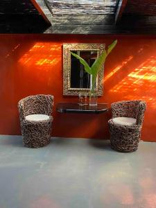 two chairs and a table with a mirror and a plant at Amasundu Beach House Trafalgar in Southbroom