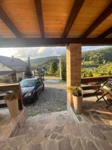 a patio with a car parked under a wooden roof at CASA IKA&MATEI in Borşa