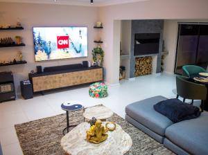 a living room with a couch and a tv at Sapphire Seas Beach Apartment in Humewood