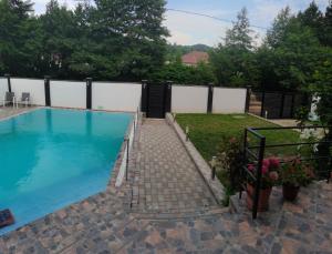 a swimming pool in a backyard with a fence at LaBebe - Vidraru in Arefu