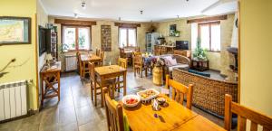 ein Restaurant mit Holztischen und -stühlen und einer Küche in der Unterkunft Casa Rural Korteta in Tolosa