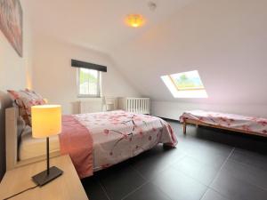 1 dormitorio con 1 cama y 1 mesa con lámpara en Sur les Thiers en Lierneux