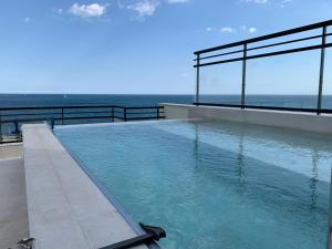 a swimming pool with the ocean in the background at La Punta COLORS By DLV in Villajoyosa