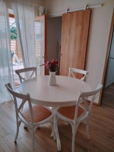 d'une table blanche et de deux chaises avec un vase. dans l'établissement Les Granges des Petits Couleurs, aux Épesses