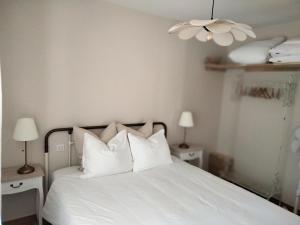 a bedroom with a white bed with white pillows at Les Granges des Petits Couleurs in Les Épesses