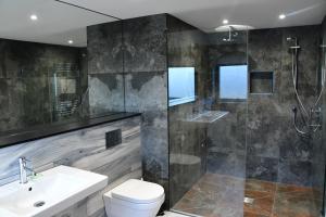 a bathroom with a shower and a toilet and a sink at Parklands in Penrith +30 photos