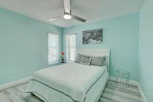 a blue bedroom with a bed and a ceiling fan at Chateau Grove in Port Saint Lucie +27 photos