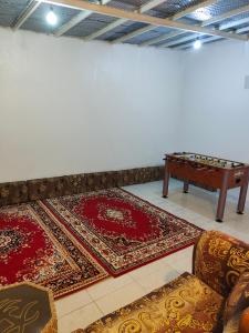 una camera con due tappeti e un tavolo con sedie di استراحة a Al Maraghah