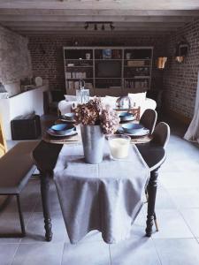 uma sala de jantar com uma mesa com pratos e flores em Élégante maison au style raffiné em Duisans