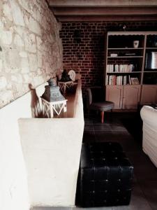 uma sala de estar com uma mesa e uma parede de tijolos em Élégante maison au style raffiné em Duisans