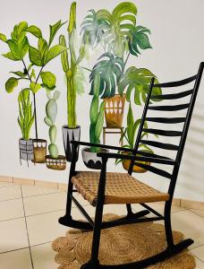 une chaise noire avec des plantes sur un mur dans l'établissement MaNà Rooms and Apartment, à Telese