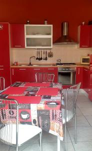 a kitchen with red cabinets and a table with chairs at La Casita in Reggio di Calabria