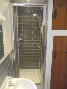 a bathroom with a shower with a sink and a mirror at Rose Cottage. Richmond, North Yorkshire in Richmond
