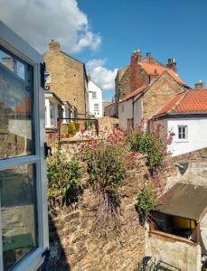 里士滿的住宿－Rose Cottage. Richmond, North Yorkshire，享有带房屋的城镇的窗户景致。