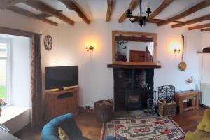 a living room with a fireplace and a television at Rose Cottage. Richmond, North Yorkshire in Richmond