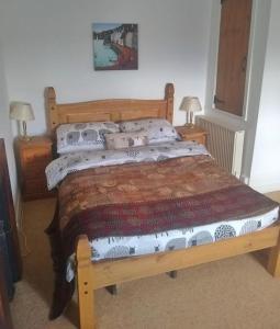 a bedroom with a wooden bed with pillows at Rose Cottage. Richmond, North Yorkshire in Richmond