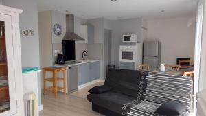 a living room with a couch and a kitchen at WELCOME Logement avec terrasse proche Bordeaux in Saint-André-de-Cubzac