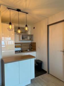 uma cozinha com um balcão e três luzes em SAPIN 2 em Les Adrets