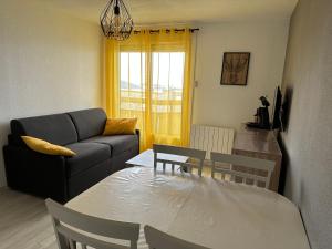 uma sala de estar com uma mesa e um sofá em SAPIN 2 em Les Adrets