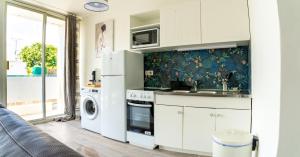a kitchen with a refrigerator and a washing machine at Lumineux 2 pièces proche Paris et Eurodisney in Villemomble
