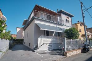 une maison blanche avec un balcon dans une rue dans l'établissement Casa Maluna, à La Spezia