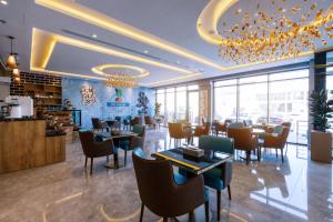 Iris Boutique Narjis في الرياض: مطعم بطاولات وكراسي في غرفة بها نوافذ