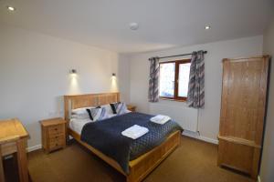 a bedroom with a bed with two towels on it at Aikbeck Lodge in Penrith