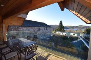 a patio with a table and chairs on a balcony at Aikbeck Lodge in Penrith