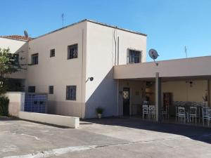 - un bâtiment blanc avec un parking en face dans l'établissement POUSADA MONTE HOREB, à Cachoeira Paulista