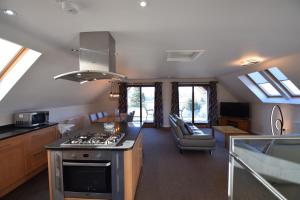a kitchen with a stove and a living room at Aikbeck Lodge in Penrith