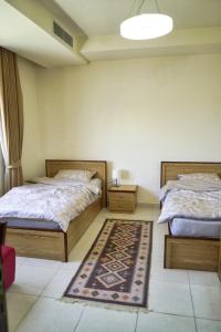 sypialnia z 2 łóżkami i dywanem na podłodze w obiekcie شقة فاخرة و واسعة من 4 غرف مع وسائل الراحة الحديثة Spacious 4-Room Apartment with Modern Amenities w mieście Amman