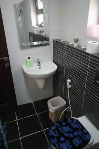 W łazience znajduje się umywalka, toaleta i lustro. w obiekcie شقة فاخرة و واسعة من 4 غرف مع وسائل الراحة الحديثة Spacious 4-Room Apartment with Modern Amenities w mieście Amman