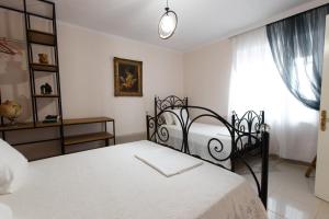 a bedroom with a bed with white sheets and a window at Martin Villa Gjirokaster in Gjirokastër