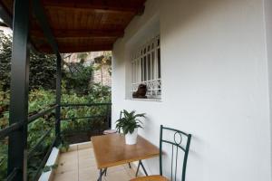 a table and chairs on a balcony with a plant at Martin Villa Gjirokaster in Gjirokastër
