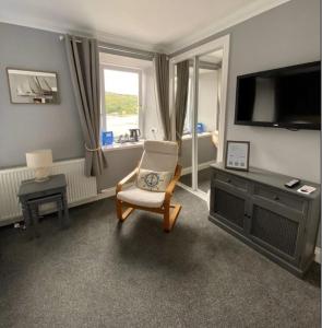 a living room with a chair and a television at The Anchor Inn in Garelochhead