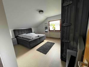 um quarto com uma cama, um sofá e uma janela em Ferienwohnung Hohberg em Albstadt