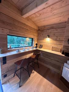 Holzhütte mit einem Schreibtisch und einem Fenster in der Unterkunft Le Chalet in Les Sorinières