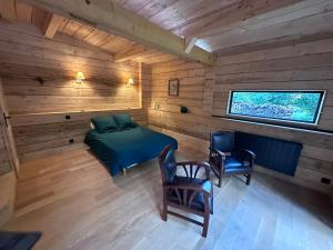 Habitación con cama y TV en una cabaña en Le Chalet, en Les Sorinières