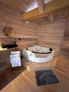 Le Chalet في Les Sorinières: حوض استحمام في غرفة مع جدران خشبية
