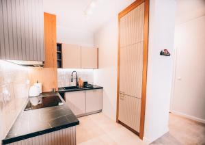 a kitchen with white cabinets and black counter tops at Marinero Apartament in Puck