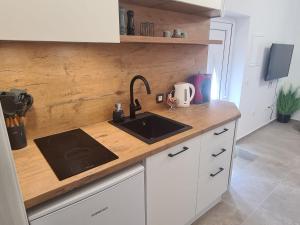 a kitchen with a sink and a wooden counter top at Lady Di apartments in Kaštela